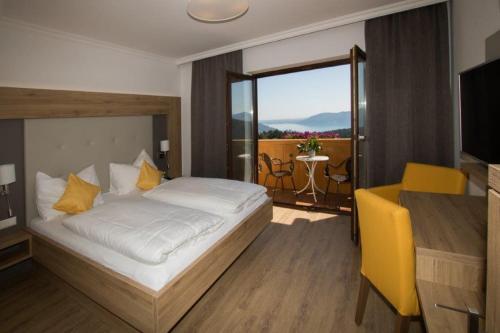 1 dormitorio con 1 cama y balcón con mesa en Ferienhotel Hofer superior, en Strass im Attergau