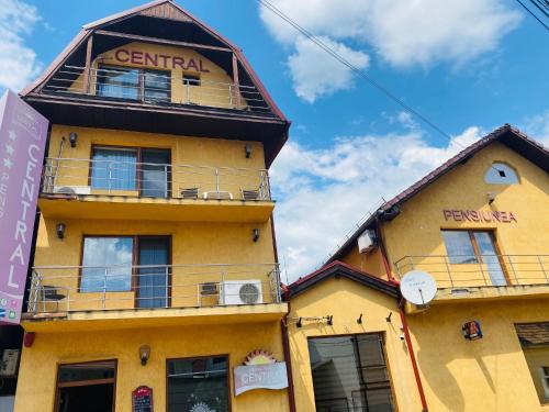 żółty budynek z balkonem na górze w obiekcie Pensiunea Central w mieście Reghin