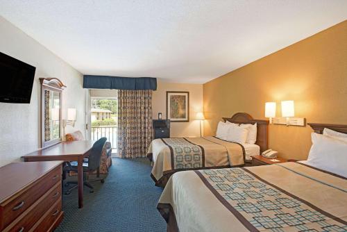 a hotel room with two beds and a desk at Days Inn by Wyndham Charlotte/Woodlawn Near Carowinds in Charlotte