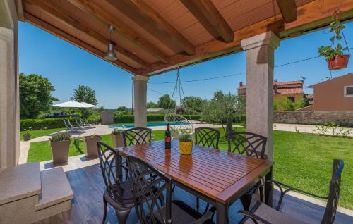 a wooden table and chairs on a patio at Holiday House Vita in Tinjan