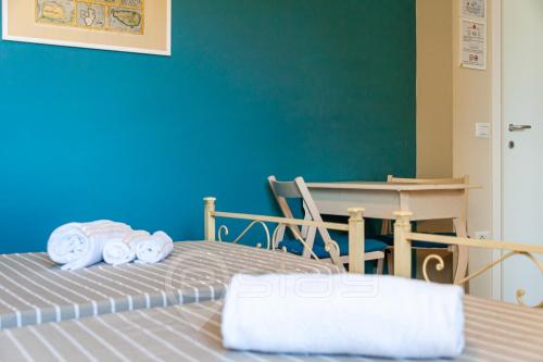Habitación con cama, mesa y toallas. en House Marcella Suites - Near the Beach, en Cagliari