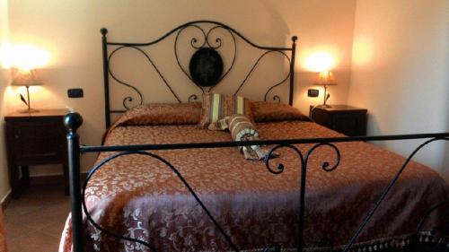 een slaapkamer met een bed met een metalen frame en twee lampen bij Agriturismo Camemi di Paternico Ettore Piazza Armerina (EN) in Piazza Armerina