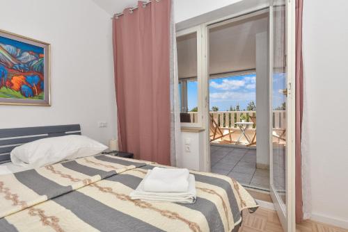 a bedroom with a bed and a balcony at House Santro in Baška Voda