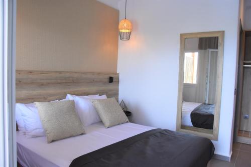a bedroom with a white bed and a mirror at CASA DI PIETRA MYKONOS in Klouvas
