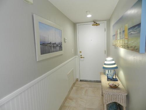 a hallway with a white door and a table at Vacation in Comfort and luxury - "THE SHERWIN" Oceanfront Condominium 906 in Daytona Beach Shores