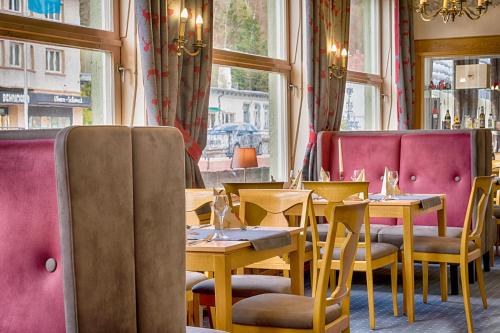 a restaurant with tables and chairs and a window at Dom-Hotel in St. Blasien