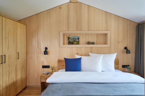 リーツラーンにあるSpycher - Chalets für 2の木製の壁のベッドルーム1室(大型ベッド1台付)