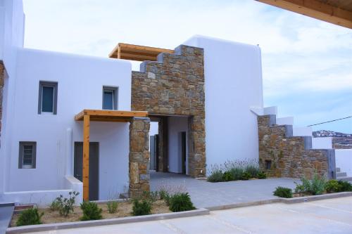 a house with white walls and a stone wall at CASA DI PIETRA MYKONOS in Klouvas