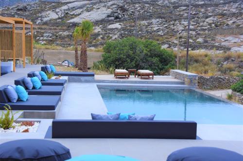 a swimming pool with blue pillows and a swimming pool at CASA DI PIETRA MYKONOS in Klouvas