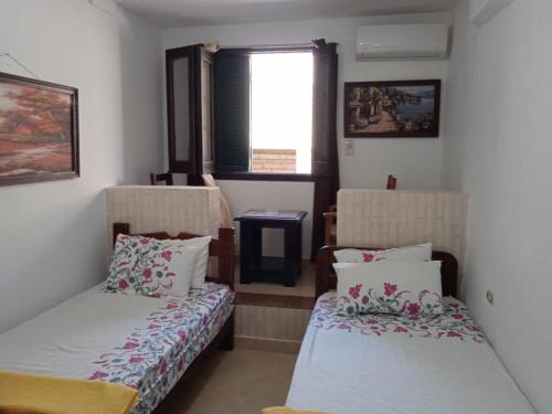 Pokój z 2 łóżkami i oknem w obiekcie 2B equipped basement chalet with 2 beds pool view green beach villa 114b w mieście El Alamein