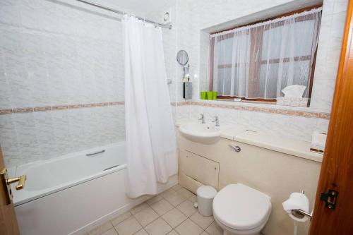 a bathroom with a toilet and a tub and a sink at Tollgate Hotel & Leisure in Stoke on Trent