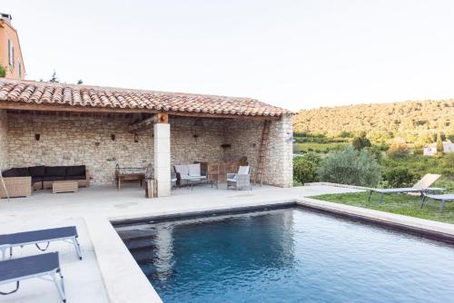 a house with a swimming pool in front of a building at Le Mas Silvestre in Saint-Saturnin-dʼApt