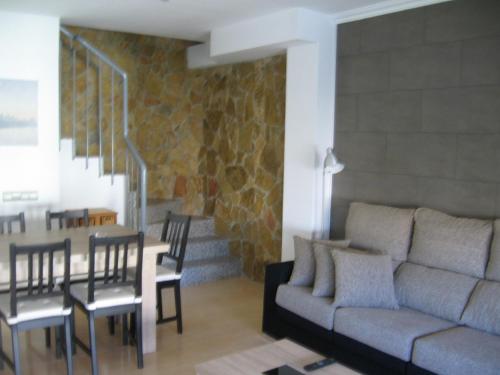 ein Wohnzimmer mit einem Sofa, einem Tisch und Stühlen in der Unterkunft Duplex junto a un Parque in Tortosa