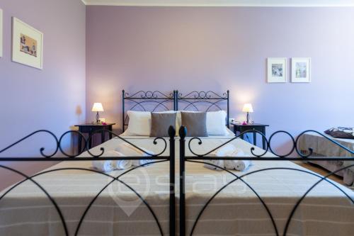 - une chambre avec un grand lit et 2 tables de chevet dans l'établissement House Marcella, à Cagliari