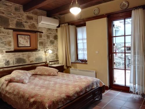 a bedroom with a bed and a stone wall at Viraggas Traditional hotel in Vrástama