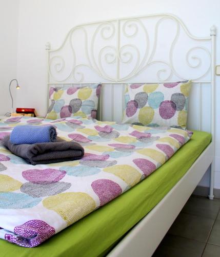 un letto con un copriletto colorato e dei cuscini sopra di Casa del Sol a Morro del Jable