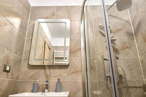 a bathroom with a shower and a sink and a mirror at Alezzi Blue Sky in Năvodari