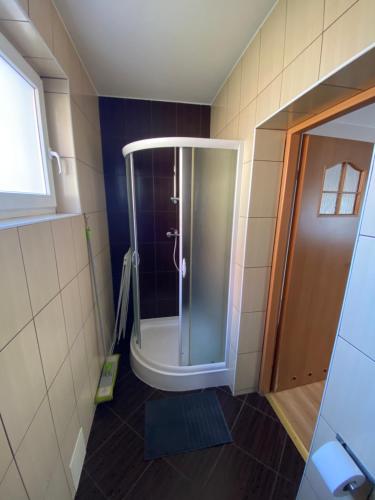 W łazience znajduje się prysznic ze szklanymi drzwiami. w obiekcie Pokoje U rybaka w mieście Stężyca