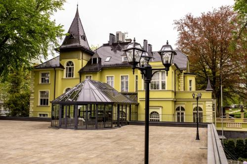 a large yellow building with a gazebo in front of it at Villatoro in Zgorzelec