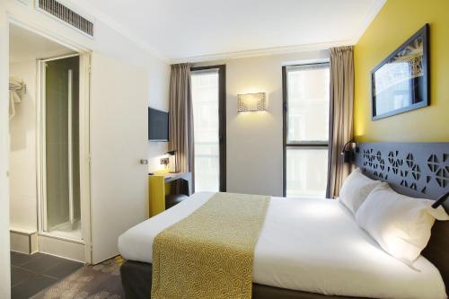 Postel nebo postele na pokoji v ubytování Hotel Eiffel Capitol