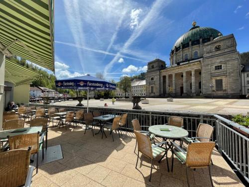 a patio with tables and chairs and a building at Dom-Hotel in St. Blasien