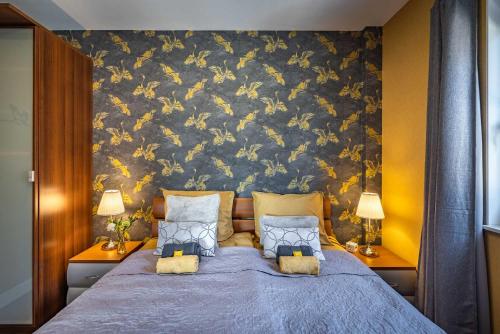 a bedroom with a blue bed with a floral wall at De Heerlijkheid Hensbroek in Hensbroek