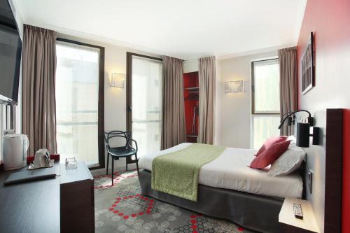 Pokój hotelowy z łóżkiem i krzesłem w obiekcie Hotel Eiffel Capitol w Paryżu