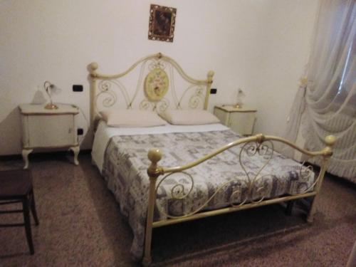 a bedroom with a white bed and two night tables at Appartamenti sapori di campagna in Pescantina