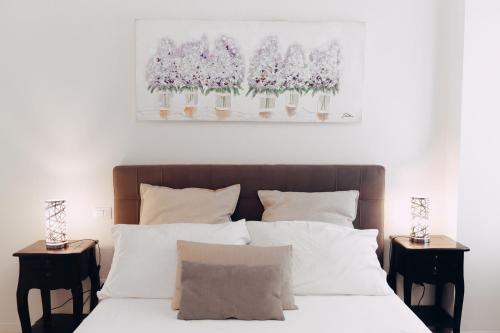 ein Schlafzimmer mit einem Bett mit Blumen in Vasen an der Wand in der Unterkunft Grand Central Room in Bologna
