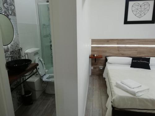 1 dormitorio con 1 cama y baño con lavamanos en B&B Giordano, en Porto SantʼElpidio