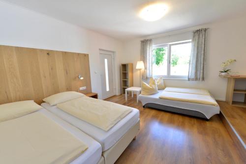 a hotel room with two beds and a window at Hotel Garni Pension Gambrinus in Passau