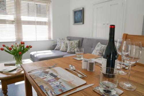 a living room with a table with a bottle of wine at The Annex, Tregoddick Barn in Penzance