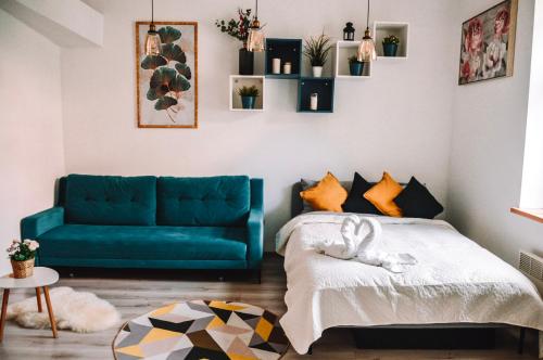 a living room with a blue couch and a bed at LUCKY 7 apartment in Liepāja