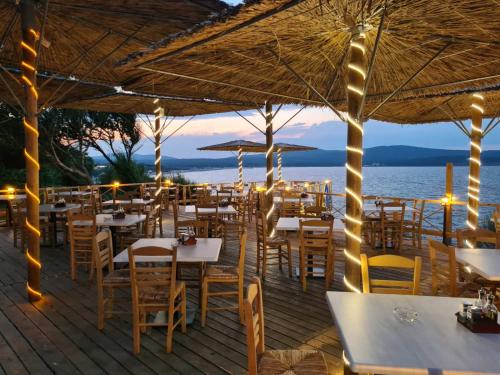 un restaurante con mesas y sillas y vistas al agua en Hotel Nikola, en Primorsko