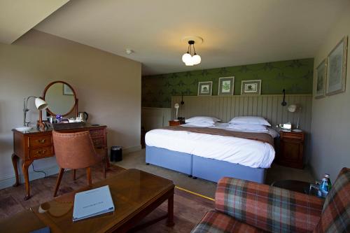 a bedroom with a bed and a table with a mirror at The Groes Inn in Conwy