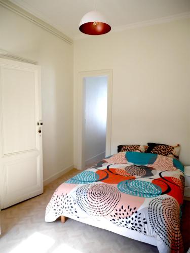 une chambre avec un lit avec une couette colorée dans l'établissement Villa Week-End, à Arcachon