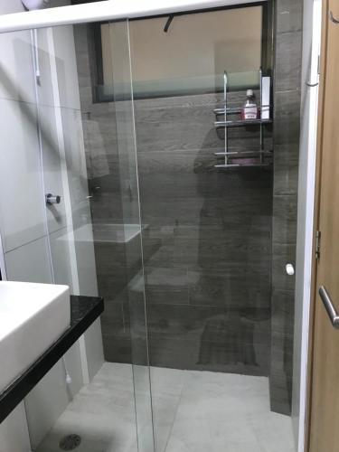 a glass shower in a bathroom with a sink at MAUÍ BEACH RESIDENCE - Beira-mar Tamandaré- Próximo a Igreja de São Pedro- PE in Tamandaré