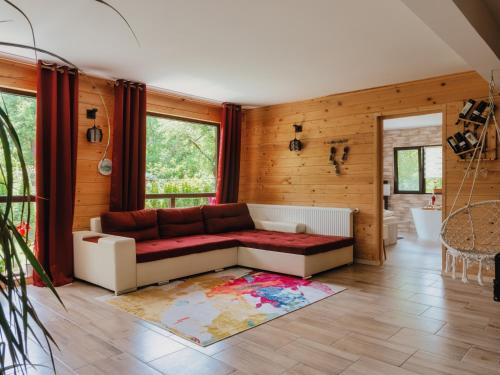 ein Wohnzimmer mit einem Sofa und einem Teppich in der Unterkunft River Residence Chalet in Stațiunea Climaterică Sâmbăta