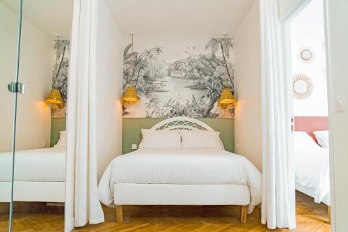 una camera con due letti e un dipinto sul muro di La Maioneta Vieux-Nice a Nizza