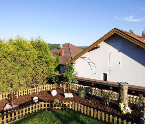 a garden in front of a house with a fence at Ferienwohnung Familie Stuhr in Staatz