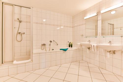 a bathroom with a shower and a sink and a tub at Apartment Sunshine in Zempin