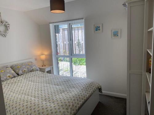 a bedroom with a bed and a window at Oliver's Yard in Helston