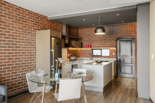 a kitchen with a table and a brick wall at Easy Stay - The Vantage Rosebank in Johannesburg