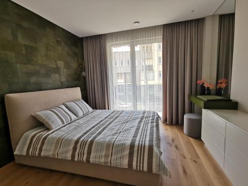 a bedroom with a bed and a large window at MyCasa CBD in Vilnius