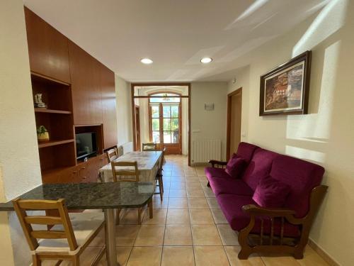 a living room with a purple couch and a table at La Badia Nova in Sant Felíu de Pallarols