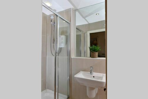 uma casa de banho com um lavatório e um chuveiro em Modern studio apartment in Leeds City Centre (LS1) em Leeds