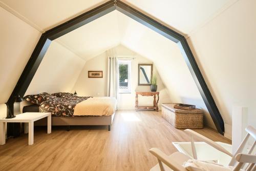 een slaapkamer met een bed en een groot raam bij Apartment Bolwerkzicht in Middelburg