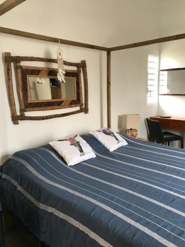 a bed with two pillows on it in a room at LES ALOÈS By CREYOL ANIMAL in Grand-Bourg