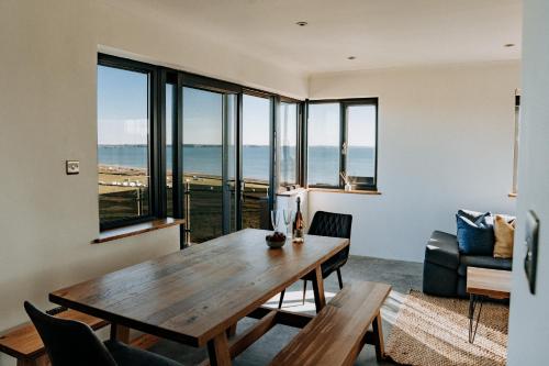 a living room with a wooden table and a view of the ocean at Ty Melyn, Newgale in Newgale