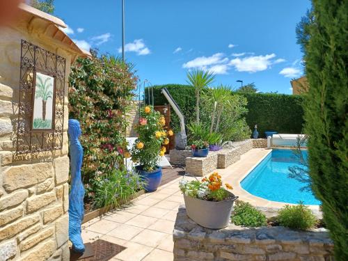 un jardin avec une piscine et quelques plantes dans l'établissement Lou Bagnou Mi-Clos, à Bagnols-sur-Cèze